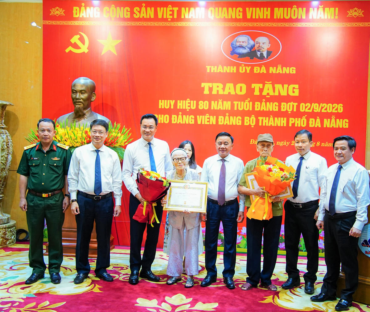 Thường trực Ban Bí thư Trần Cẩm Tú (ở giữa) trao Huy hiệu 80 năm tuổi Đảng, tặng hoa và chúc mừng Đảng viên Nguyễn Thị Hữu và đảng viên Hồ Văn Lang. Ảnh: TT.