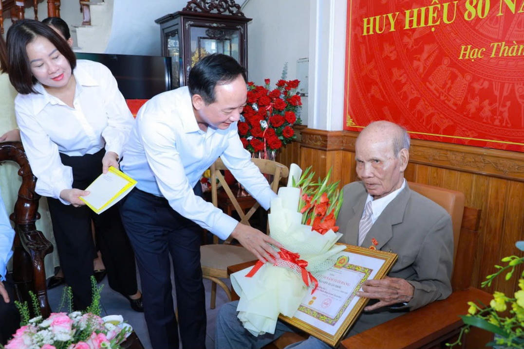 Ông Trịnh Văn Quyết trao huy hiệu 80 năm tuổi Đảng cho ông Nguyễn Xuân Trớc. Ảnh: Minh Hiếu
