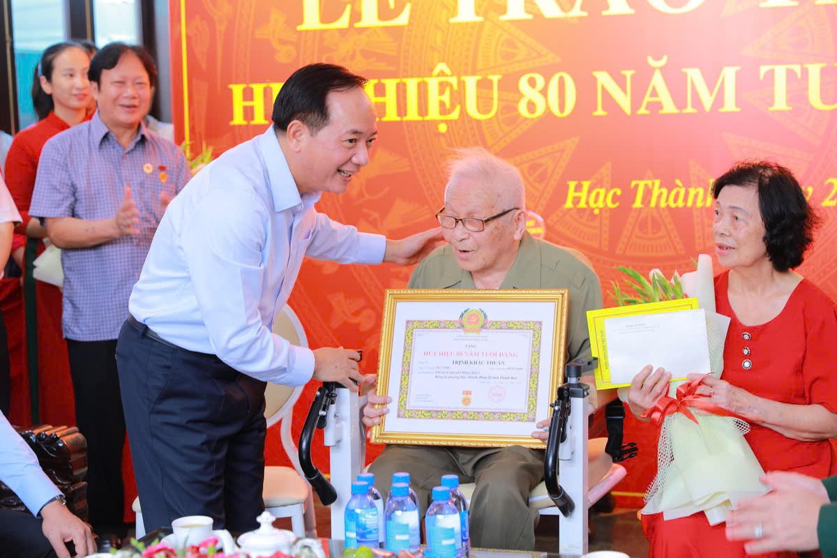 Ông Trịnh Văn Quyết trao huy hiệu 80 năm tuổi Đảng cho ông Trịnh Khắc Thuần. Ảnh: Minh Hiếu