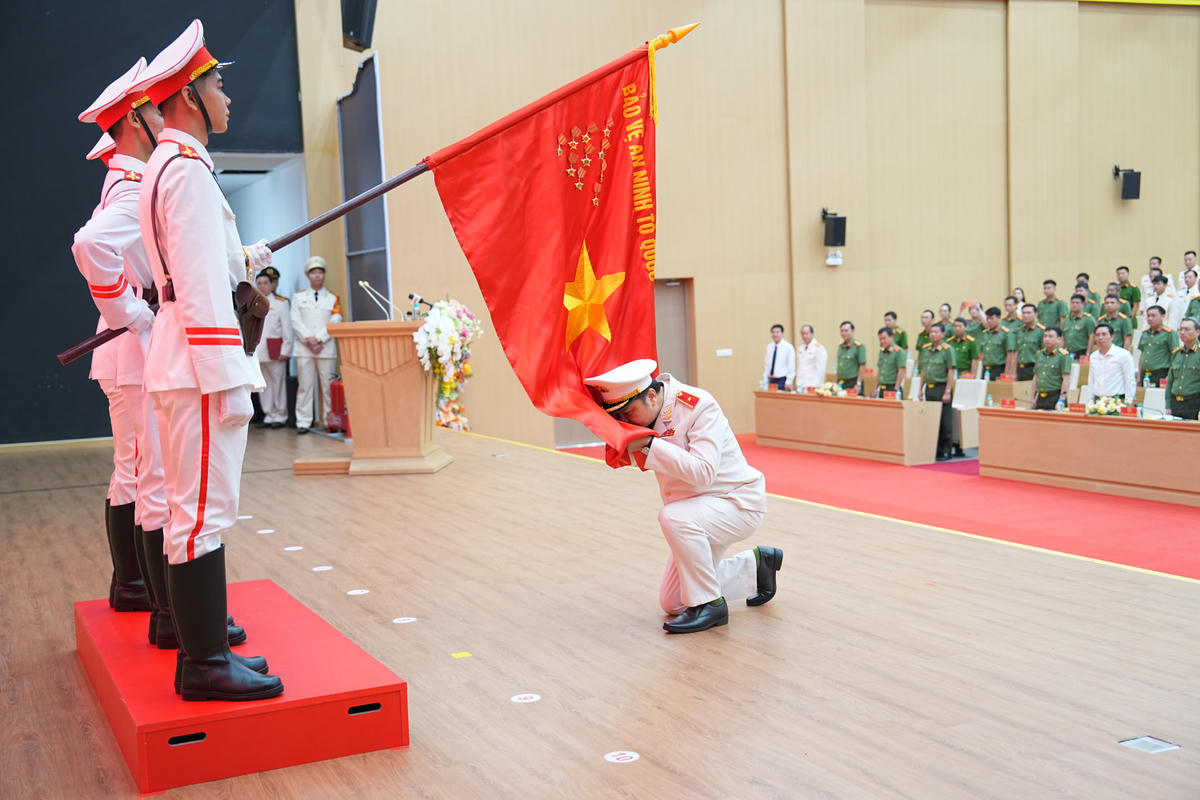 Thiếu tướng Nguyễn Tiến Trung, Giám đốc Công an thành phố thực hiện nghi lễ tuyên thệ dưới lá cờ vinh quang của Tổ quốc. Ảnh: Công an Quảng Ninh.