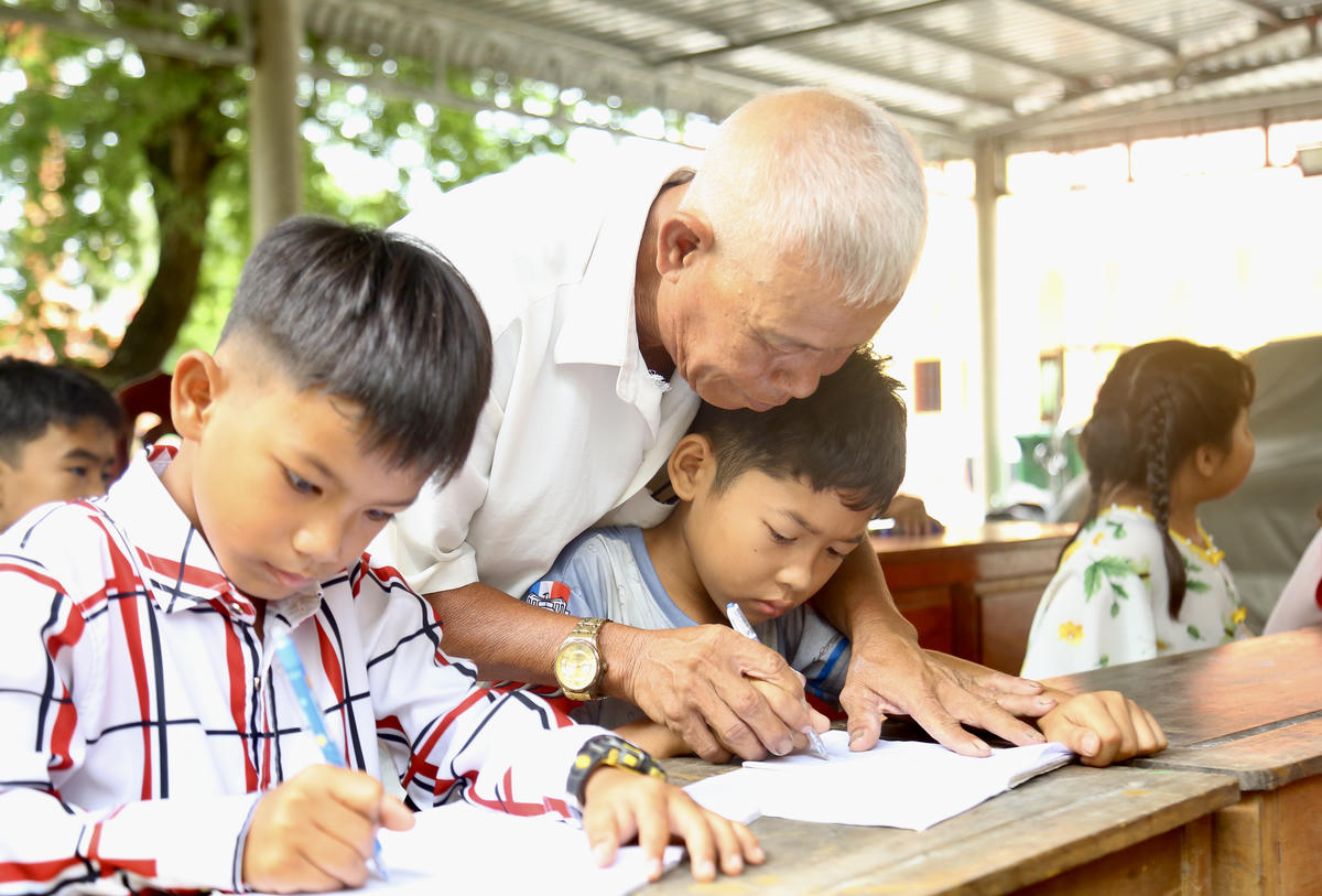 Ông Danh Sại chỉnh sửa từng nét bút cho học sinh. Ảnh: Thanh Tiến