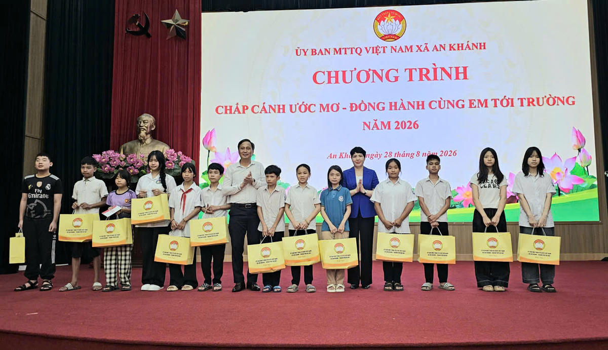 Bà Trương Thị Dung, Phó Bí thư Thường trực, Chủ tịch HĐND và ông Tạ Văn Thắng, Chủ tịch Ủy ban MTTQ Việt Nam xã, Trưởng Ban vận động Quỹ "Vì người nghèo" xã An Khánh trao quà cho các em học sinh. Ảnh: Đạt Lê