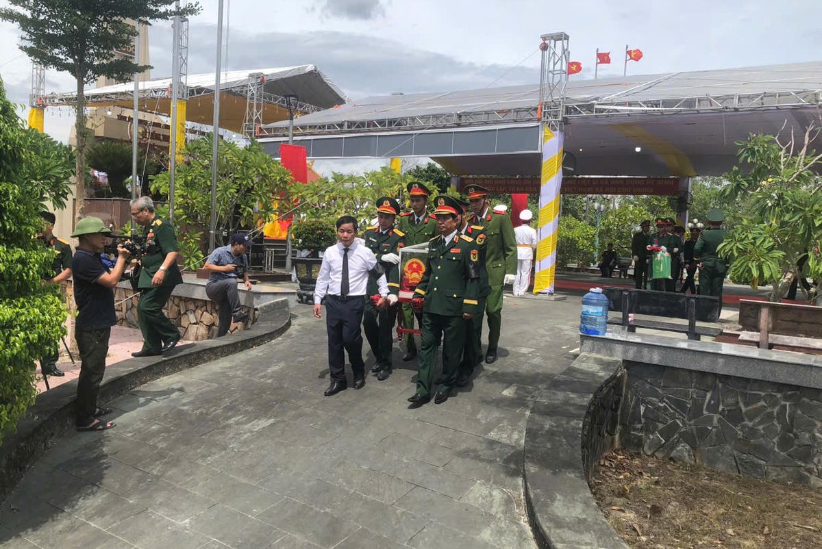 Đại biểu, cán bộ, chiến sĩ di chuyển hài cốt liệt sĩ đến an táng tại các phần mộ. Ảnh: N.A.