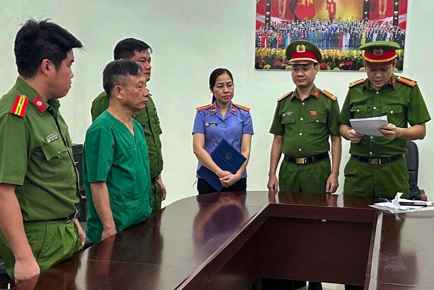 Công an đọc lệnh khởi tố Vũ Văn Trình. Ảnh: CANB