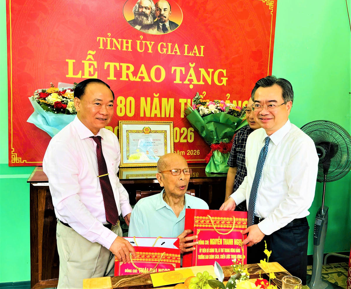 Ông Nguyễn Thanh Nghị, Trưởng ban Chính sách, chiến lược Trung ương (bên phải) và Bí thư Tỉnh ủy Gia Lai Thái Đại Ngọc (bên trái) tặng quà và trao Huy hiệu 80 năm tuổi Đảng cho đảng viên lão thành Phan Ngọc Bích. Ảnh: CĐ.