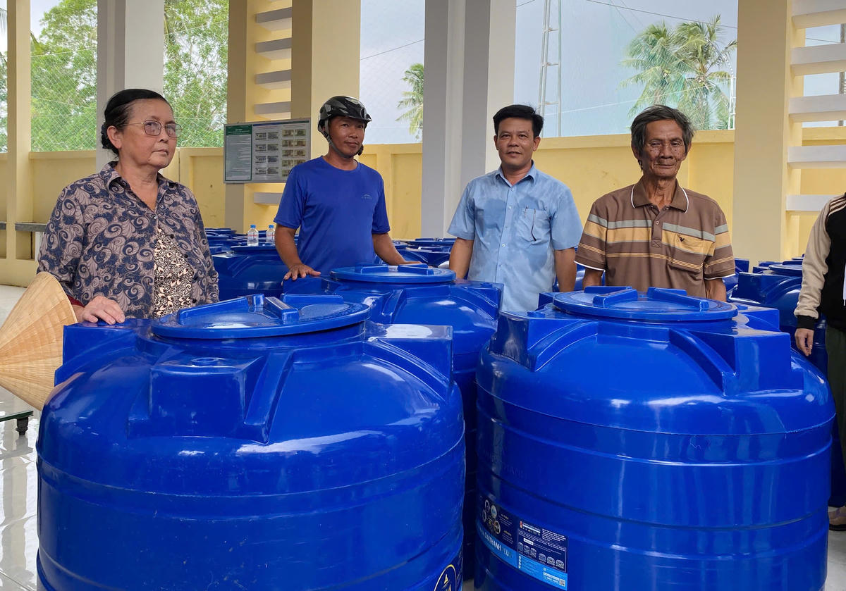 Người dân vui mừng nhận bồn chứa nước do Ủy ban MTTQ Việt Nam tỉnh Vĩnh Long phối hợp đơn vị tài trợ trao tặng, góp phần chủ động trữ nước ngọt phục vụ sinh hoạt trong mùa khô. (Ảnh: An Xuyên).