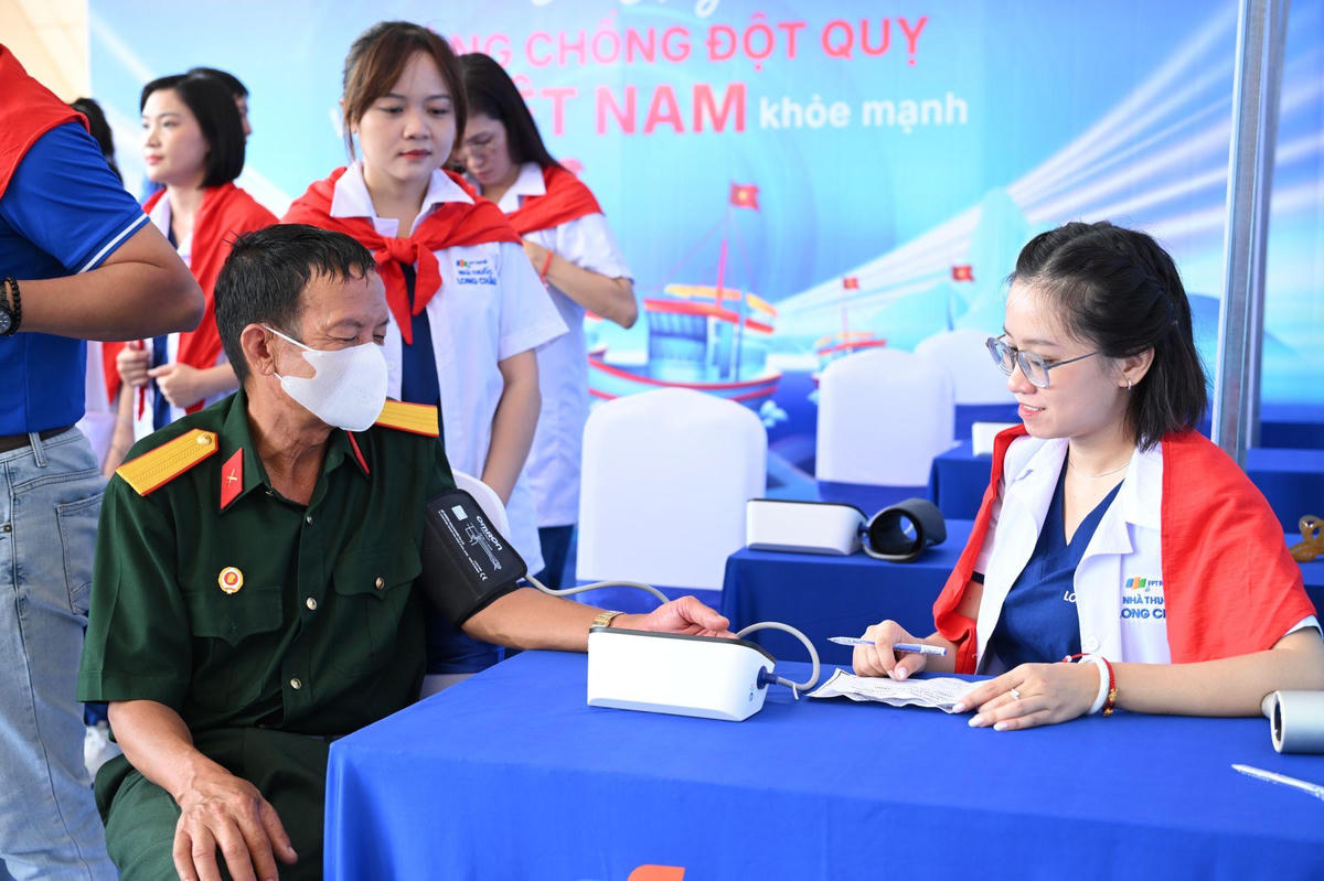 Dược sĩ hỗ trợ người dân kiểm tra huyết áp, phát hiện cảnh báo rung nhĩ. Ảnh: Hoàng Khánh.