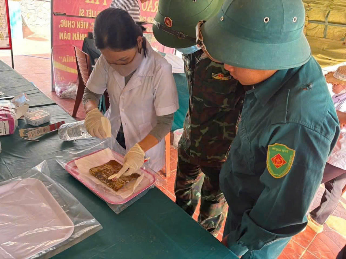 Lực lượng chức năng đang lấy mẫu hài cốt liệt sĩ phục vụ giám định ADN. Ảnh: QS.