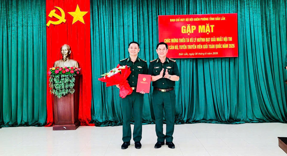 : Đại tá Nguyễn Văn Lĩnh tặng hoa và chúc mừng Thiếu tá Vũ Lý Huỳnh. Ảnh: Xuân Điền