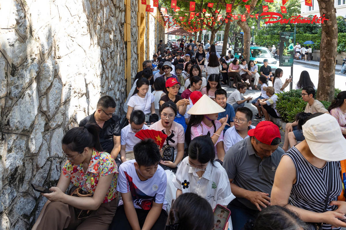Dù lượng khách tăng cao, việc xếp hàng và di chuyển tại khu vực trước di tích vẫn được duy trì khá trật tự. Nhiều người chủ động đứng dưới các khu vực có mái che, ô che nắng hoặc tìm bóng cây trong lúc chờ đến lượt.