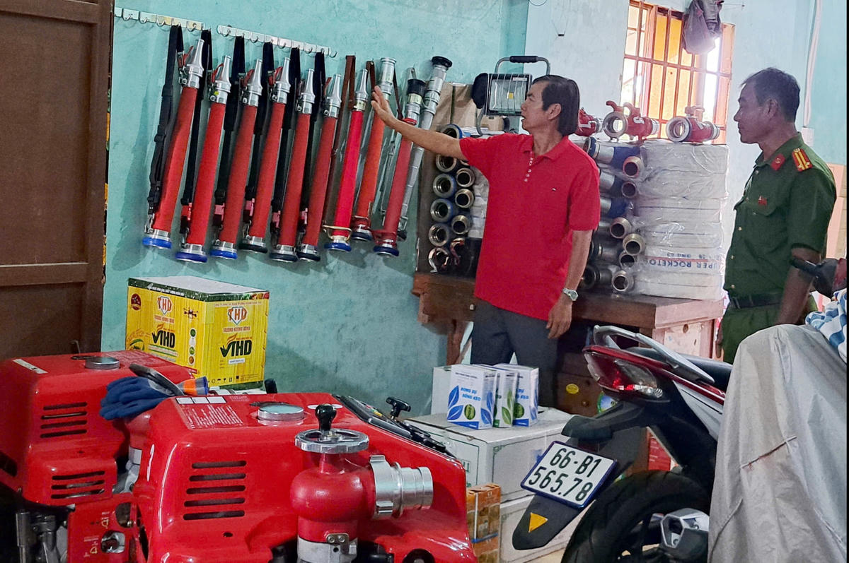 Ông Phạm Văn Nùng giới thiệu hệ thống vòi, lăng phun và thiết bị chữa cháy được đầu tư phục vụ công tác chữa cháy tại cộng đồng. (Ảnh: An Bình).