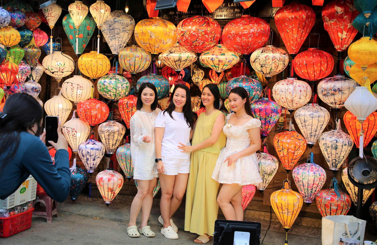 Chị Thu Hiền (áo vàng) check-in bên những chiếc lồng đèn. Ảnh: Nam Hà.