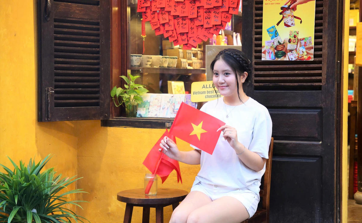 Những cô gái check-in bên lá cờ Tổ quốc. Ảnh: Chí Đại.