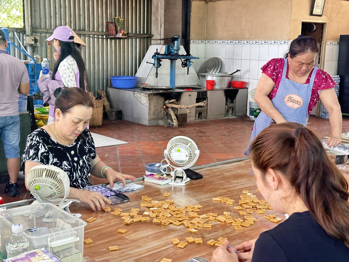 Du khách tham quan, trải nghiệm làm kẹo dừa tại một cơ sở du lịch ở Cồn Thới Sơn. (Ảnh: Thanh Lâm).