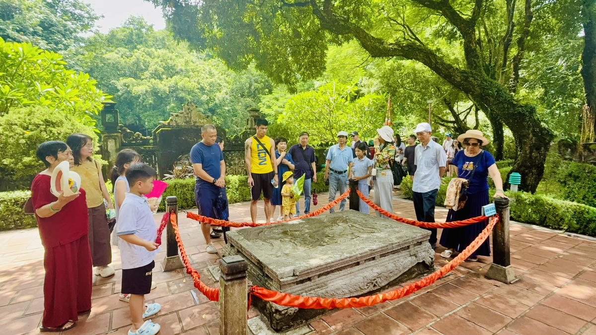 Du khách khám phá long sàng - bảo vật quốc gia trong di tích cố đô Hoa Lư. Ảnh: Đình Minh