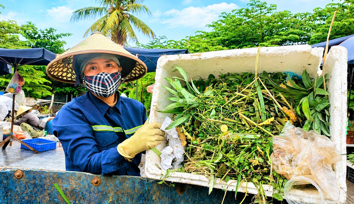Chị Võ Thị Ngọc Ngà đang thu gom rác thải tại khu vực chợ Tam Kỳ. Ảnh: Chí Đại.