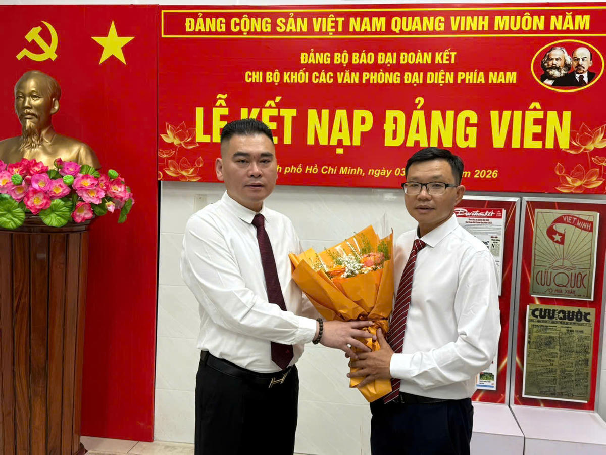 Bí thư Chi bộ Trần Bảo Trung tặng hoa chúc mừng đảng viên Trần Quốc Định. Ảnh: M.C