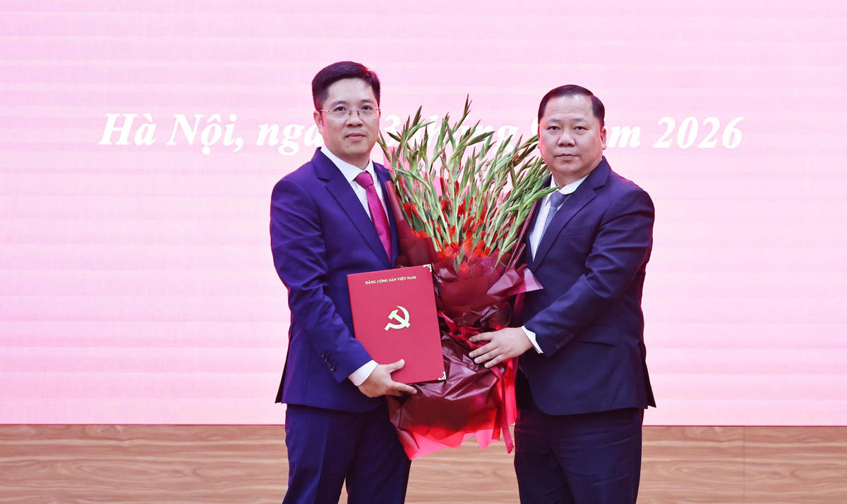 Phó Bí thư Thường trực Đảng ủy MTTQ, các đoàn thể Trung ương, Phó Chủ tịch Ủy ban Trung ương MTTQ Việt Nam Nguyễn Phi Long trao Quyết định và tặng hoa chúc mừng đồng chí Nguyễn Duy Hiển. Ảnh: Minh Đức.