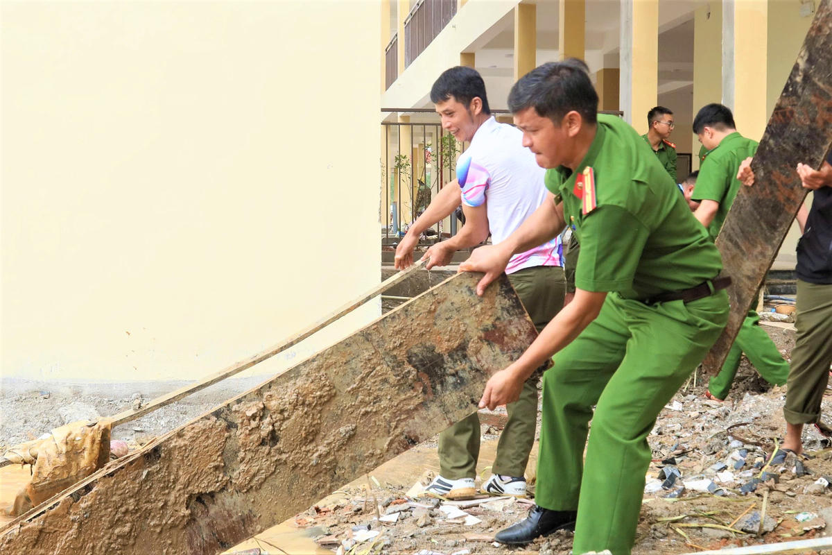 Chiến sĩ Công an đang dọn vệ sinh Trường PTNTLC-TT-THCS xã Dục Nông. Ảnh: BT.