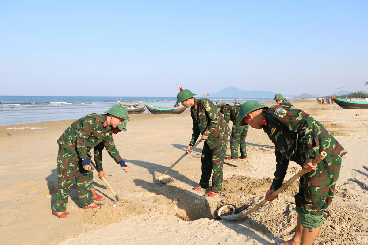 Cán bộ, chiến sĩ Trung đoàn 841 - Bộ Chỉ huy Quân sự tỉnh Hà Tĩnh phối hợp với địa phương thu gom vỏ ngao để xử lý. Ảnh: YH.