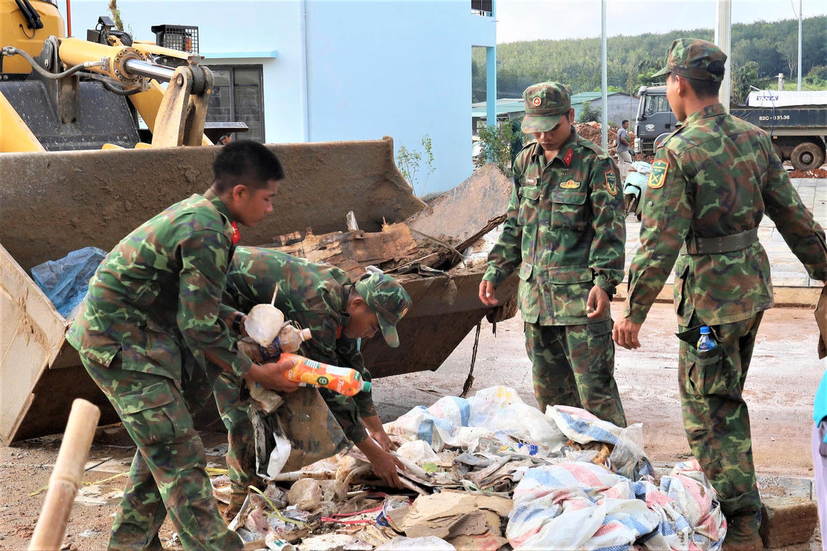 Lực lượng chức năng dọn vệ sinh trong khuôn viên Trường PTNTLC-TT-THCS xã Dục Nông. Ảnh: BT.