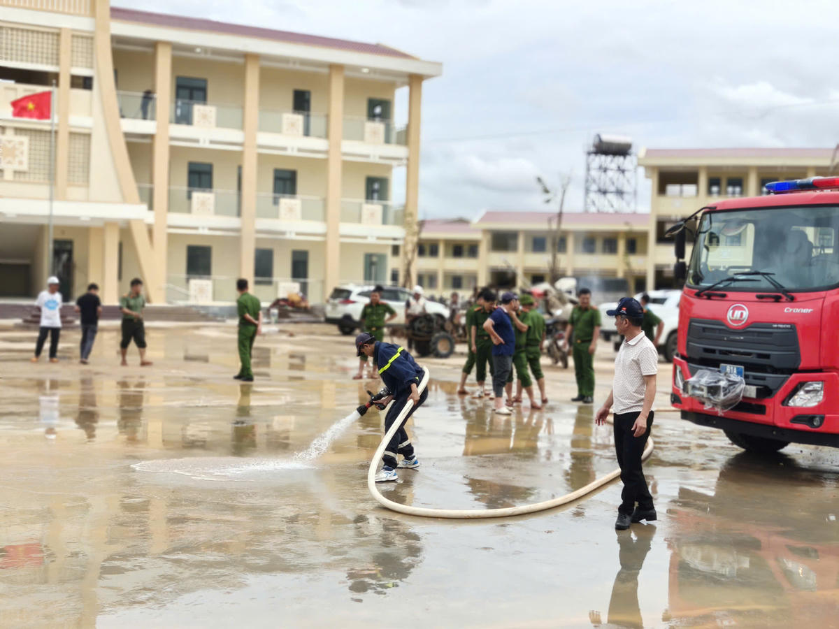 Chiến sĩ Công an tỉnh Gia Lai dùng vòi nước công suất lớn xịt rửa trôi bùn đất. Ảnh: CA.