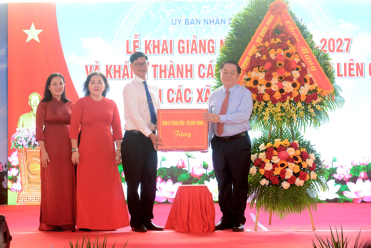 Đại tướng Nguyễn Trọng Nghĩa tặng quà động viên cán bộ giáo viên Trường THPT Chuyên Trần Văn Giàu. Ảnh: L.T.