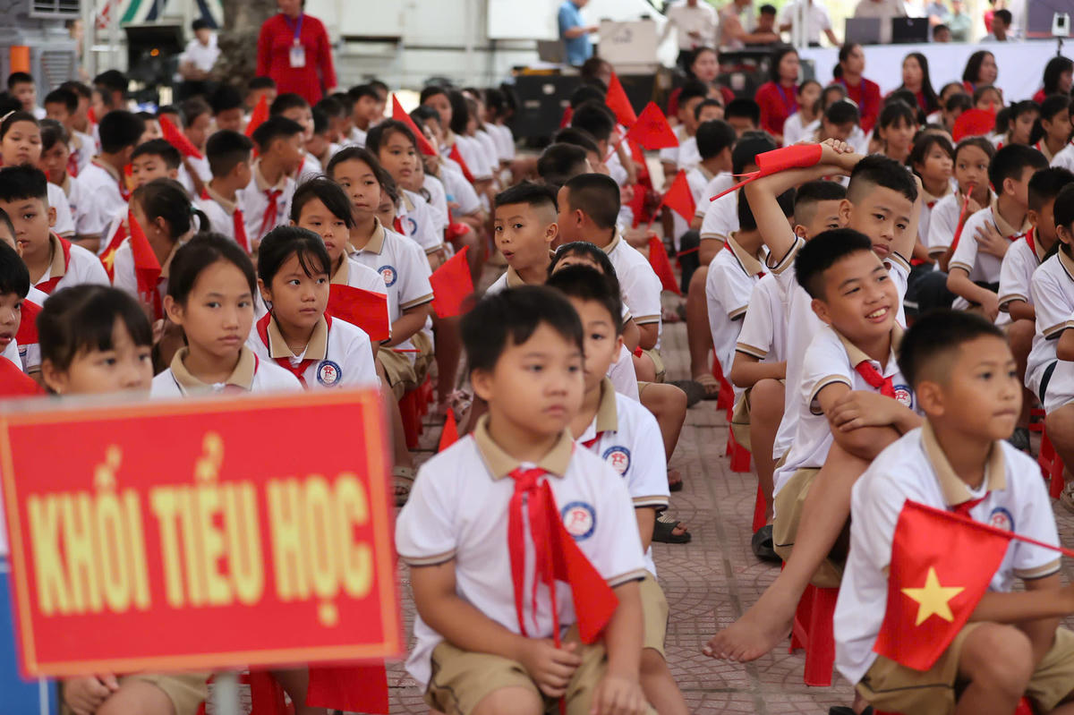 Sân trường ngập đỏ sắc cờ hoa, khăn quàng đỏ, đồng phục mới. Ảnh: Lê Hiếu.