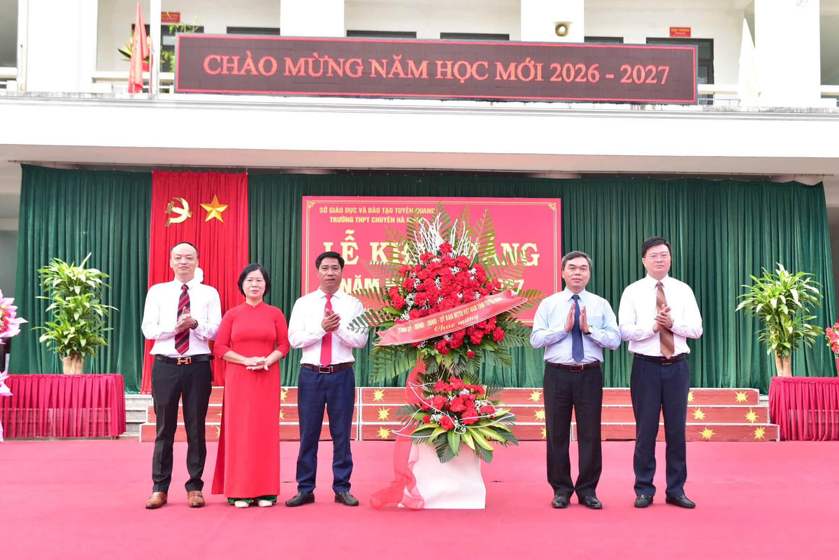 Chủ tịch Ủy ban MTTQ Việt Nam tỉnh Tuyên Quang Ma Thế Hồng tặng hoa chúc mừng nhà trường. Ảnh: MTTQ.