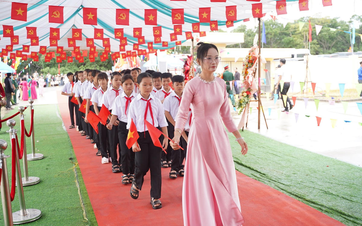 Cô giáo Trường PTNTLC TT-THCS Ia Púch dẫn học sinh vào dự khai giảng. Ảnh: ĐS.