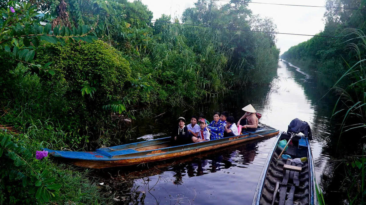 Học sinh vùng cực nam Tổ quốc đến trường khai giảng bằng xuồng máy ra điểm chính dự lễ khai giảng năm học mới. Ảnh: CTV