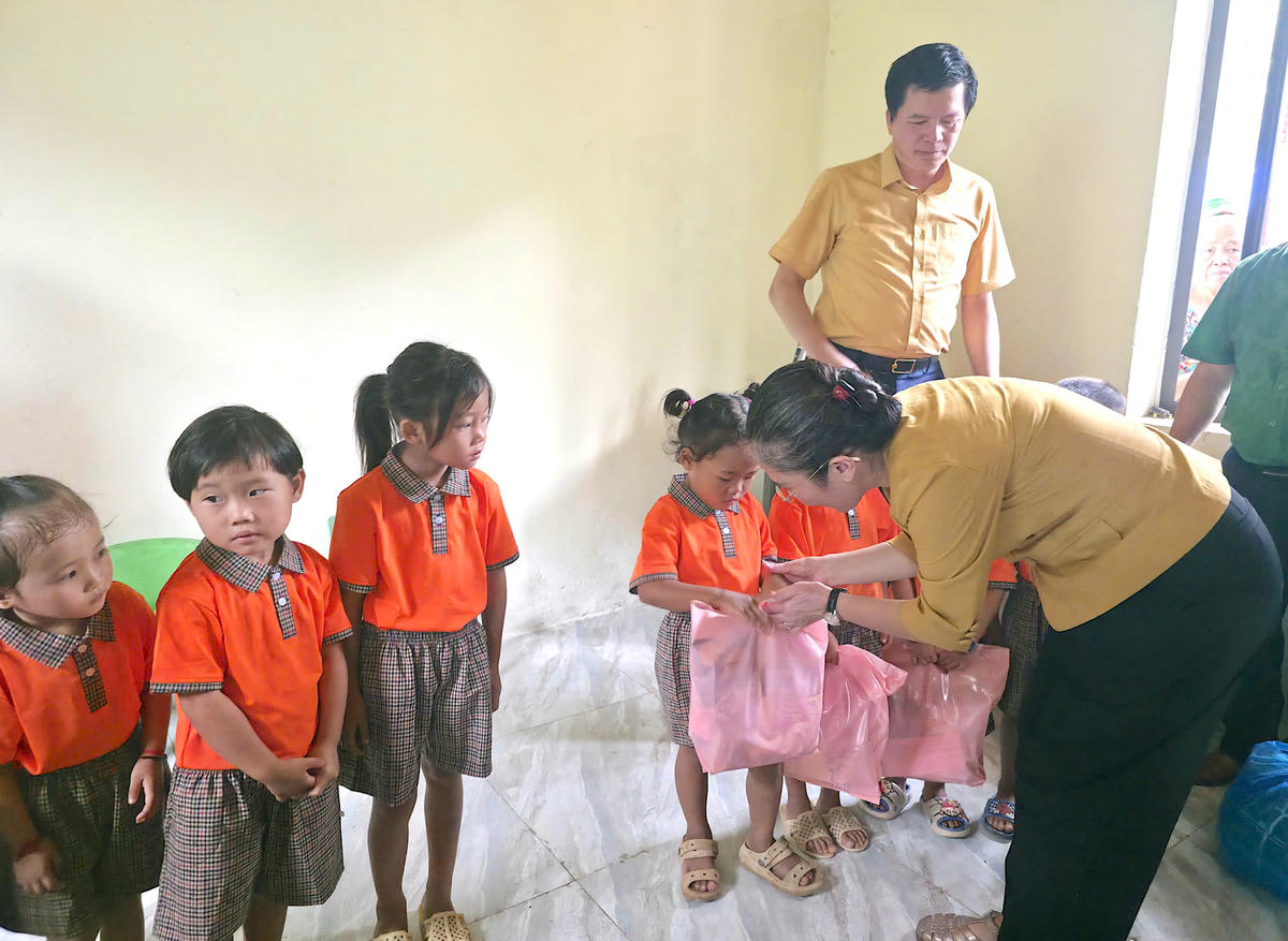 Bà Võ Thị Minh Sinh - Phó Bí thư Tỉnh ủy, Chủ tịch Ủy ban MTTQ tỉnh Nghệ An tặng quà cho các cháu tại điểm trường bản Cha Nga. Ảnh: ĐB