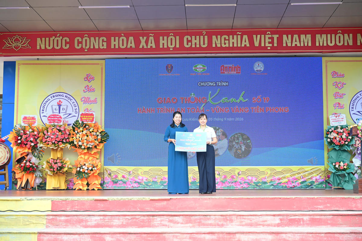 Bà Lưu Thị Mai, Đảng uỷ viên, Kế toán trưởng Công ty Cổ phần Nhựa Thiếu niên Tiền Phong trao biểu trưng tặng 1.000 mũ bảo hiểm cho đại diện Trường THCS Lưu Kiếm. 