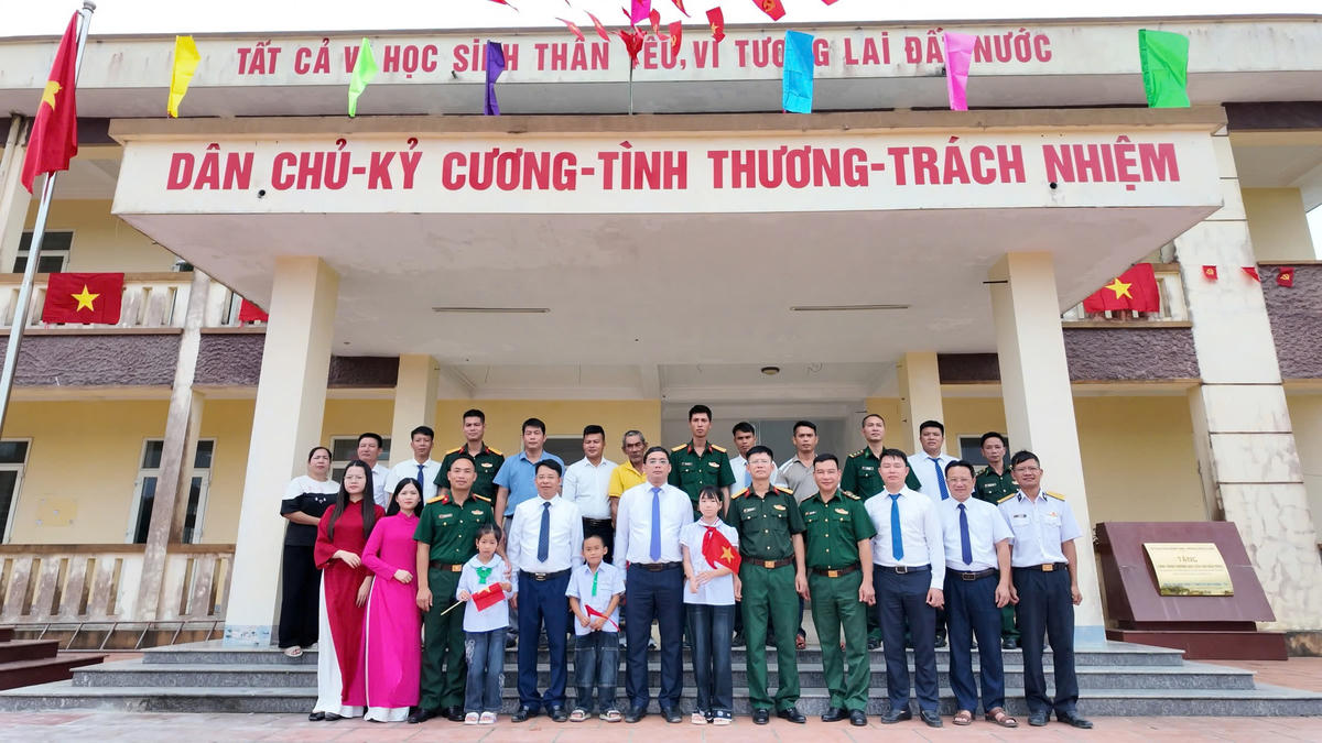 Lãnh đạo đặc khu Cô Tô cùng các thầy cô, cán bộ, chiến sĩ, phụ huynh, học sinh ở đảo Trần chụp ảnh lưu niệm trong ngày khai giảng.