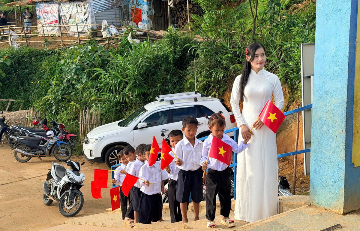 Cô giáo dẫn các em học sinh vào lớp học. Ảnh: VC.