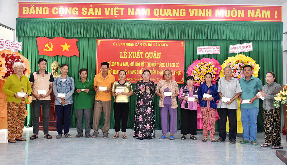Bà Hồ Thị Cẩm Đào (thứ 7 từ trái sang), Phó Bí thư Thành ủy, Chủ tịch Ủy ban MTTQ Việt Nam TP Cần Thơ, trao quà hỗ trợ 12 hộ gia đình tại lễ ra quân của xã Hồ Đắc Kiện . Ảnh Thạch Pích