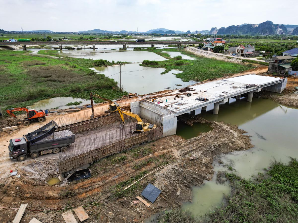 Cụ thể, gói thầu số 10 có giá trị hợp đồng 182,894 tỷ đồng, khối lượng thực hiện ước đạt 116,828 tỷ đồng. Các hạng mục đang được triển khai gồm kênh và công trình trên kênh Đông Quang, cầu Đìa Ngang, cầu Cao Lũng, cống Yên Dương, Chiếu Bạch, đê Hà Bắc và nạo vét sông Hoạt đoạn 2. Ảnh cầu Đìa Ngang, xã Tống Sơn, là điểm đầu của dự án đang được thi công.