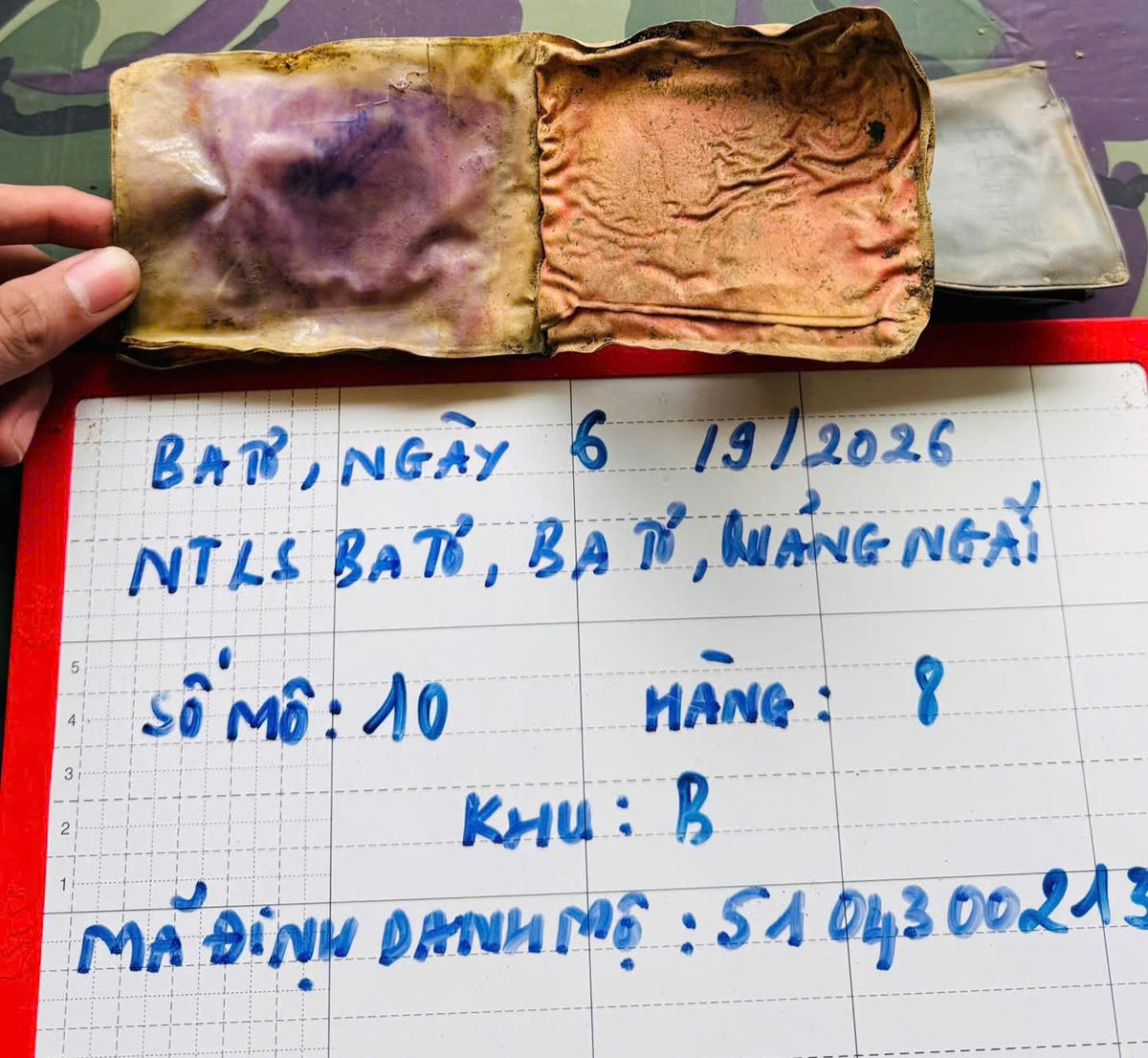 Lực lượng chức năng phát hiện các di vật trong mộ hài cốt liệt sĩ. Ảnh: QS.