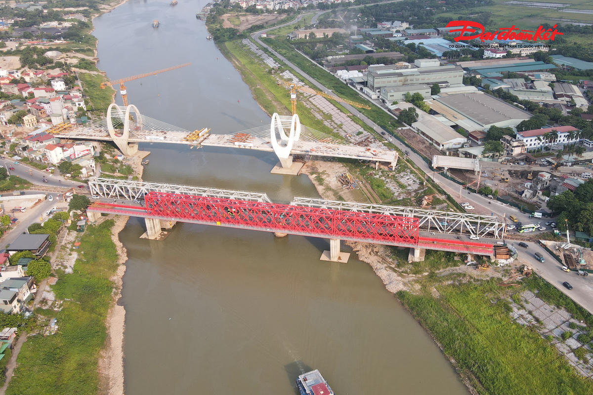 Trong khi cầu đường bộ đang chạy đua về đích, gói XL01 - cầu đường sắt Đuống cũng đang được triển khai. Hiện công trình không còn vướng mắc về mặt bằng, các trụ chính cơ bản hoàn thành và nhà thầu đang thi công những hạng mục tại hai đầu cầu. Ảnh: cầu màu đỏ.