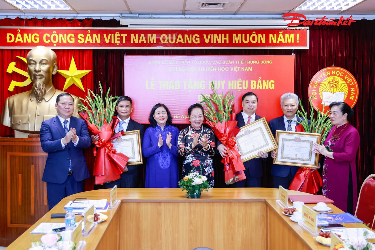 Chủ tịch Bùi Thị Minh Hoài trao tặng Huy hiệu 35 năm tuổi Đảng và tặng hoa chúc mừng các đại biểu. Ảnh: Quang Vinh.