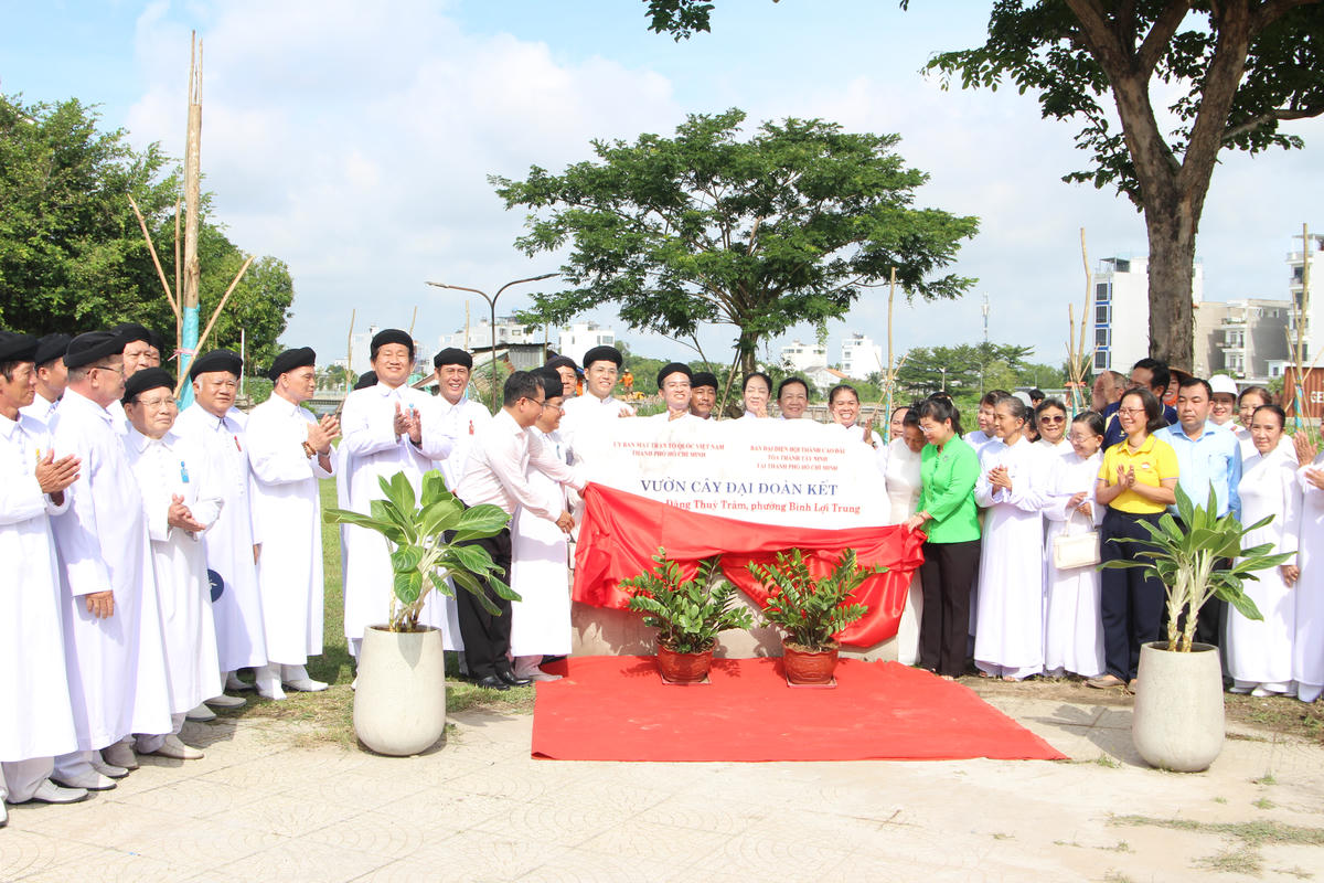 Các đại biểu thực hiện nghi thức mở vải phủ phiến đá khánh thành “Vườn cây Đại đoàn kết”. Ảnh: QĐ.