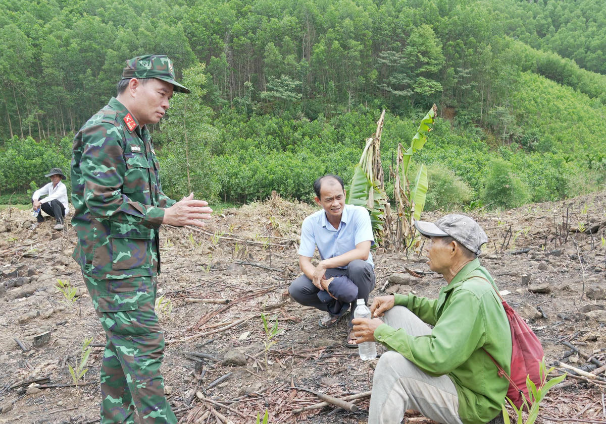 Đại tá Trịnh Công Sơn, Phó Chính ủy Bộ CHQS tỉnh Quảng Ngãi lấy thông tin từ người dân về khu vực nghi có 48 mộ tập thể liệt sĩ. Ảnh: QS.