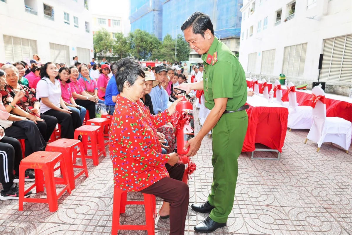 Tặng bình chữa cháy cho người dân tại ngày hội. Ảnh: MTBT.