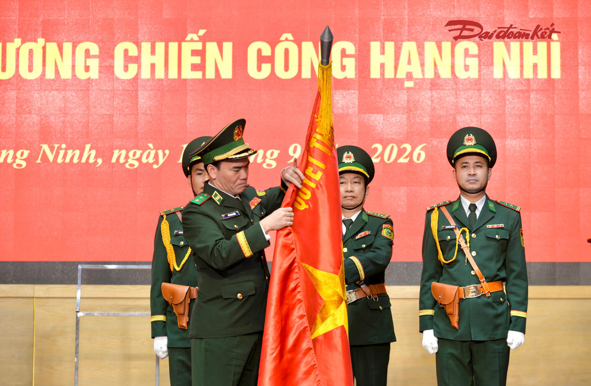 Thừa ủy quyền của Chủ tịch nước, Trung tướng Vũ Trung Kiên, Tư lệnh Bộ đội Biên phòng Việt Nam gắn Huân chương Chiến công hạng Nhì lên Quân kỳ quyết thắng của Ban chỉ huy BĐBP thành phố Quảng Ninh. Ảnh: Ngọc Anh