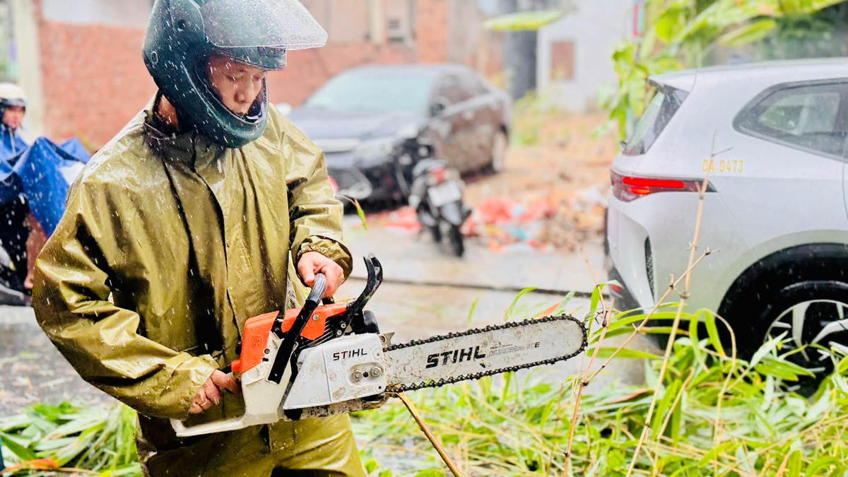 Lực lượng khẩn trương cắt, thu gom cây ngã đổ, khơi thông các vị trí thoát nước bị tắc nghẽn, bảo đảm an toàn cho người dân và phương tiện qua lại. Ảnh: Nguyễn Tú.