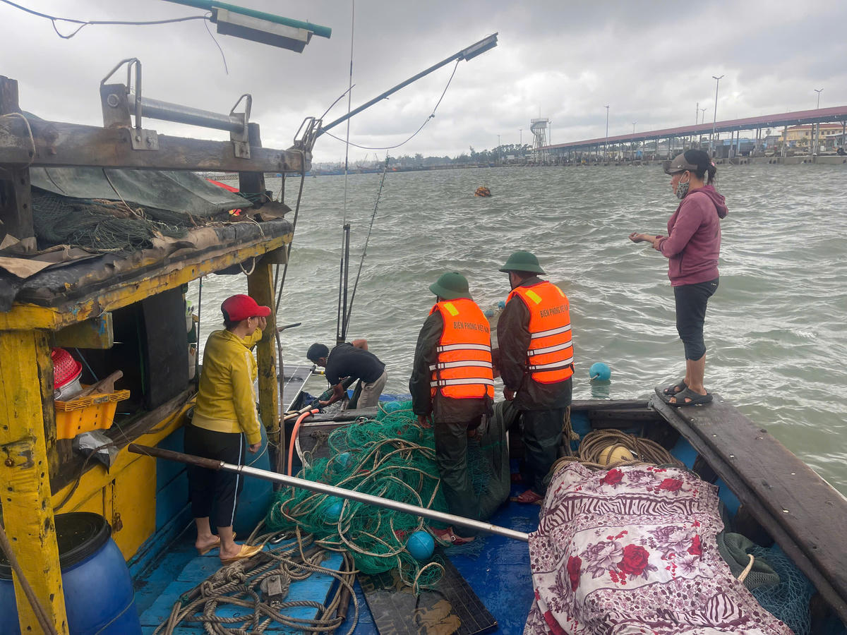 Lực lượng chức năng đang tiến hành trục vớt tàu cá bị sóng đánh chìm. Ảnh: H.D.