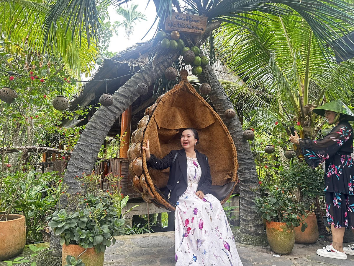 Du khách trải nghiệm không gian miệt vườn, chụp ảnh lưu niệm tại một điểm tham quan tại Cù lao An Bình. (Ảnh: Thanh Lâm).
