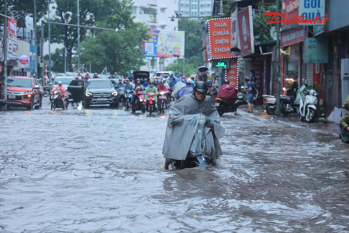 Các phương tiện, đặc biệt là xe máy, gặp khó khăn khi lưu thông qua những đoạn đường ngập úng.