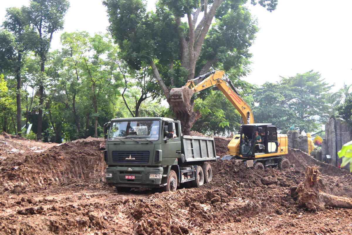 Xe ben và máy cuốc được huy động phục vụ mở rộng khu vực tìm kiếm hài cốt liệt sĩ. Ảnh: BTL