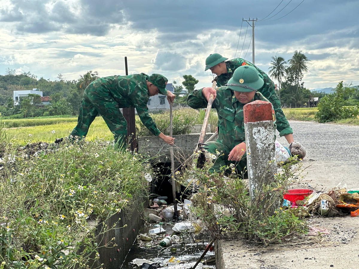 Bộ đội Biên phòng khơi thông kênh mương, dọn dẹp vệ sinh môi trường tại khu vực thôn Phú Hội, xã Tuy An Đông. Ảnh: NL.